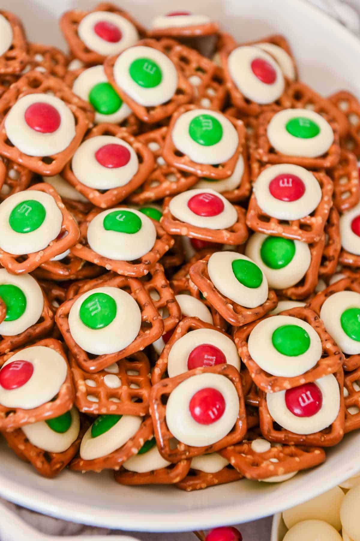 close up of pretzel white chocolate m&m in a white bowl.